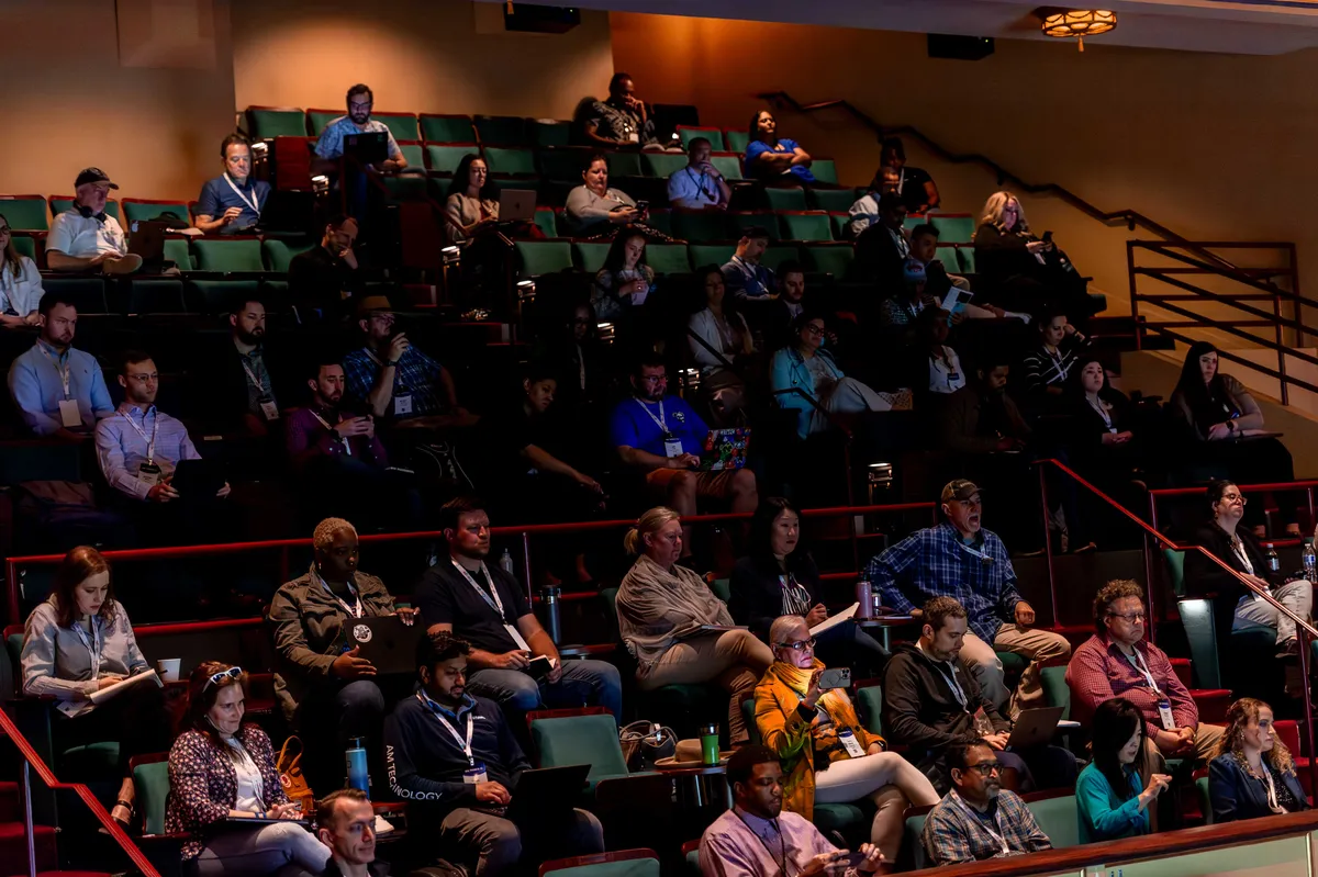Attendees taking notes from the balcony at All Things AI 2026